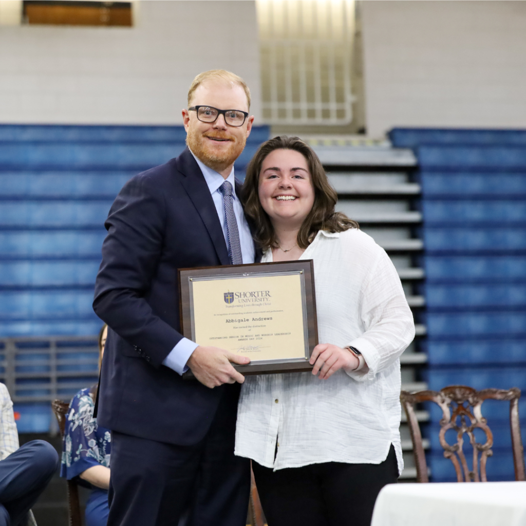 Dr. John McCluskey and Abbi Andrews standing with the award.