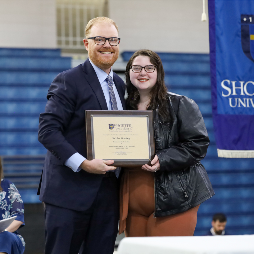 Dr. John McCluskey and Belle Nunley standing with the award.
