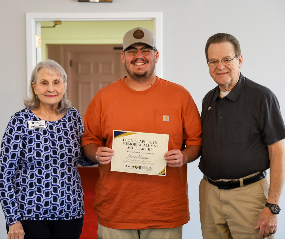 Two males and a female posing for photo and the received award 