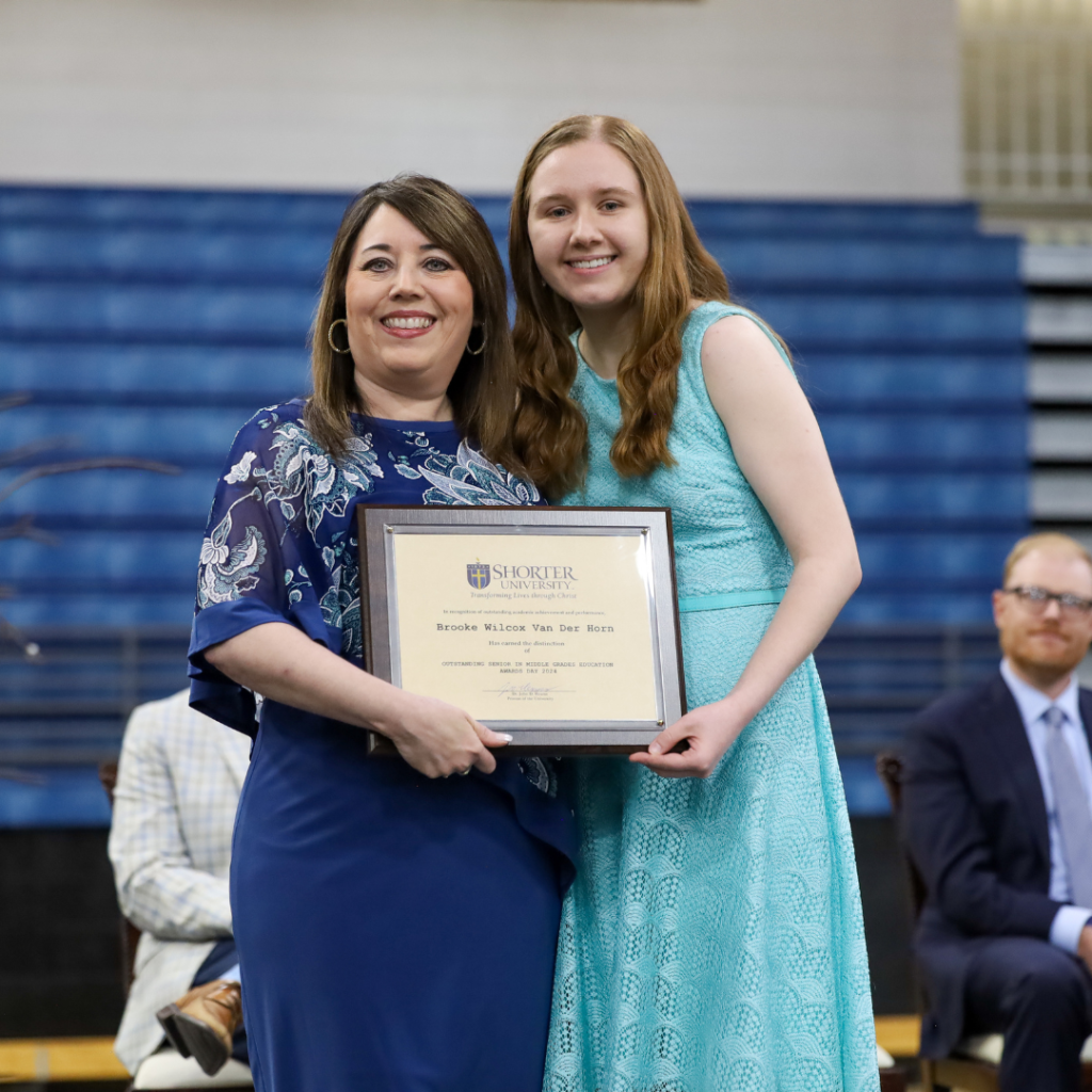 Dr. Dana King and Brooke Wilcox Van Der Horn standing with award