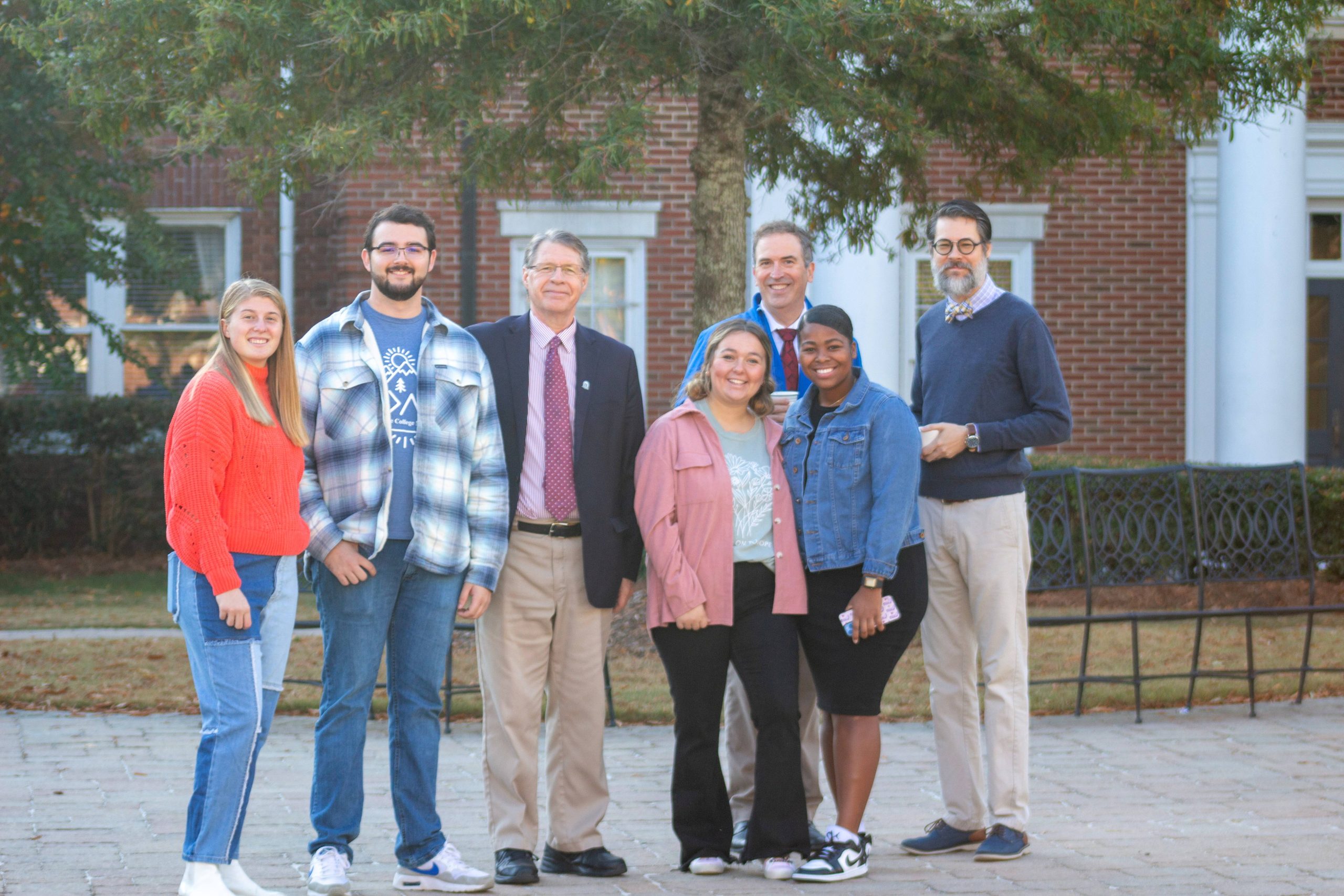 group of students three females, one male, three faculty members
