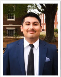 A young man in a suit smiling at the camera