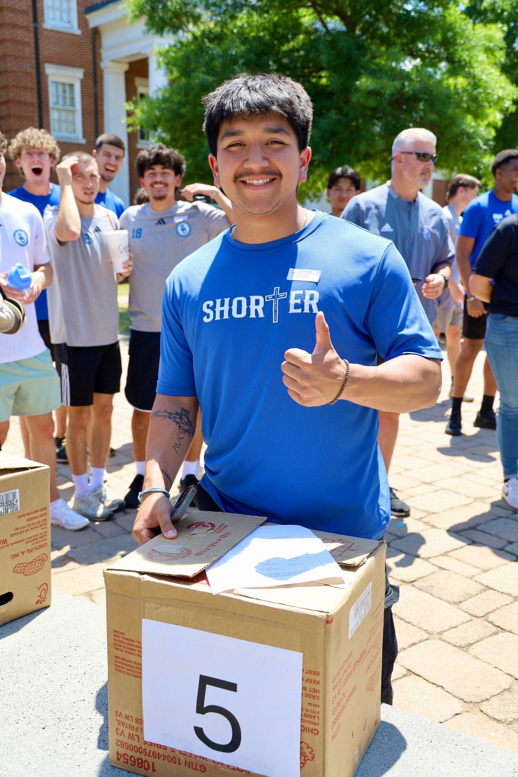 Shorter Student Smiling with thumbs up for event.