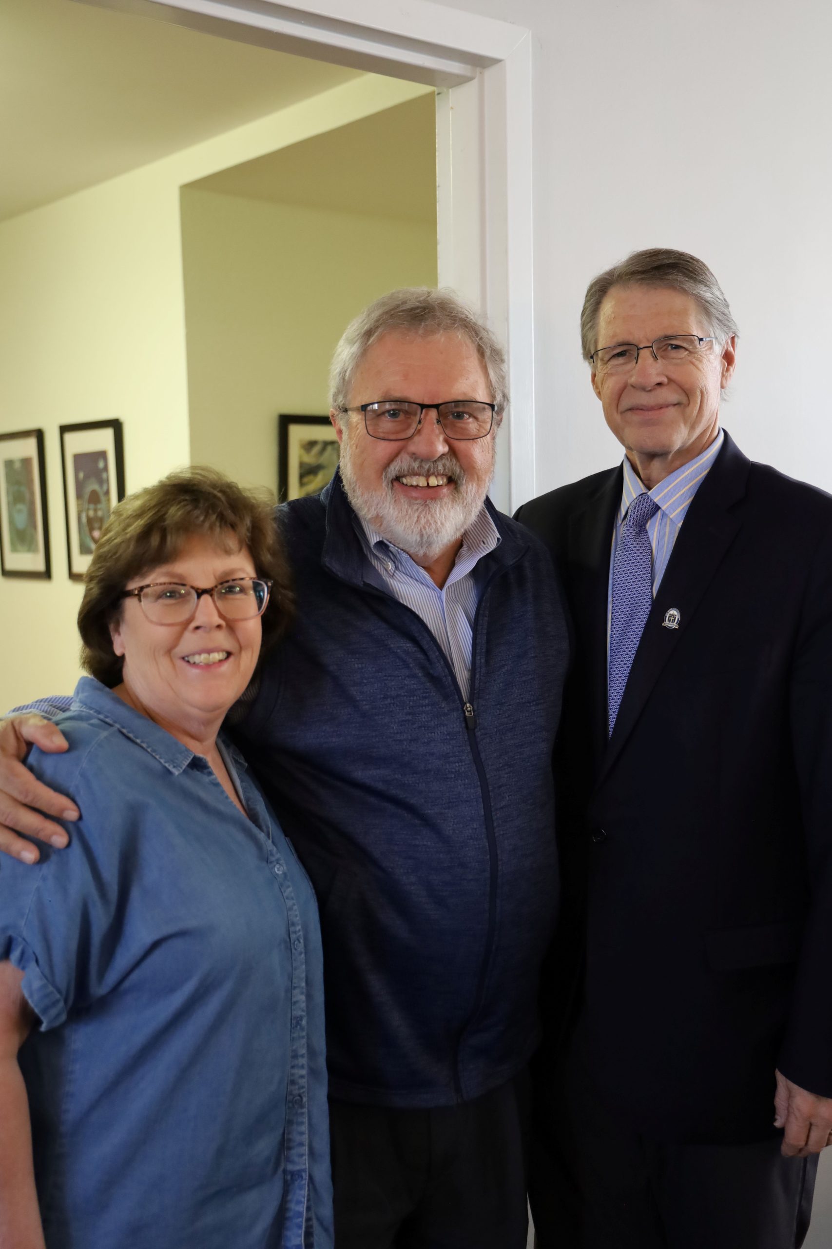 two men and a woman smiling
